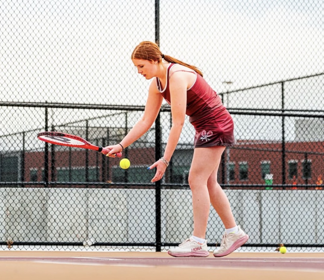 Senior Maddie McGillicuddy preparing to serve.